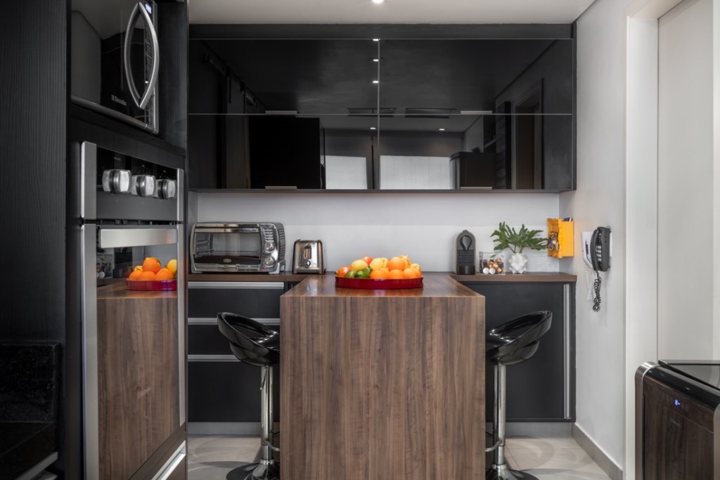 Cozinha integrada; cozinha preta; armários pretos; bancada de madeira