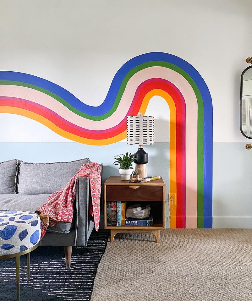 Sala de estar com um grande arco-íris pintado na parede
