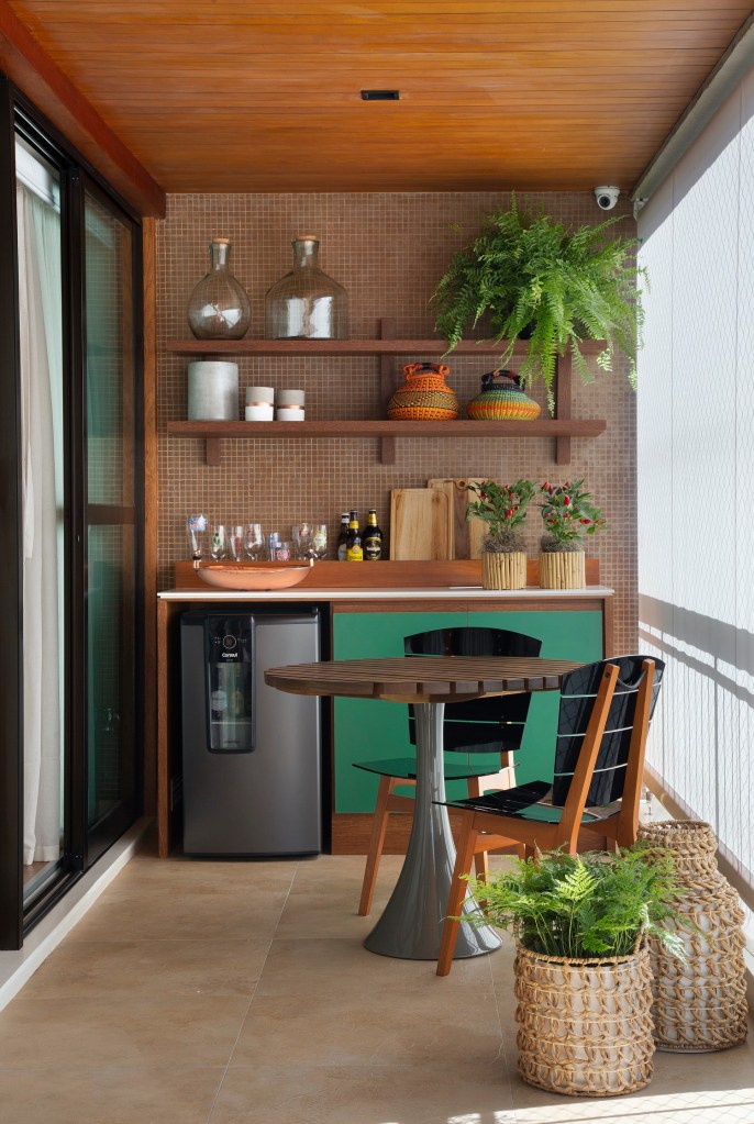 Varanda; varanda integrada; varanda pequena; área gourmet; mesa redonda pequena; prateleira; vasos de plantas