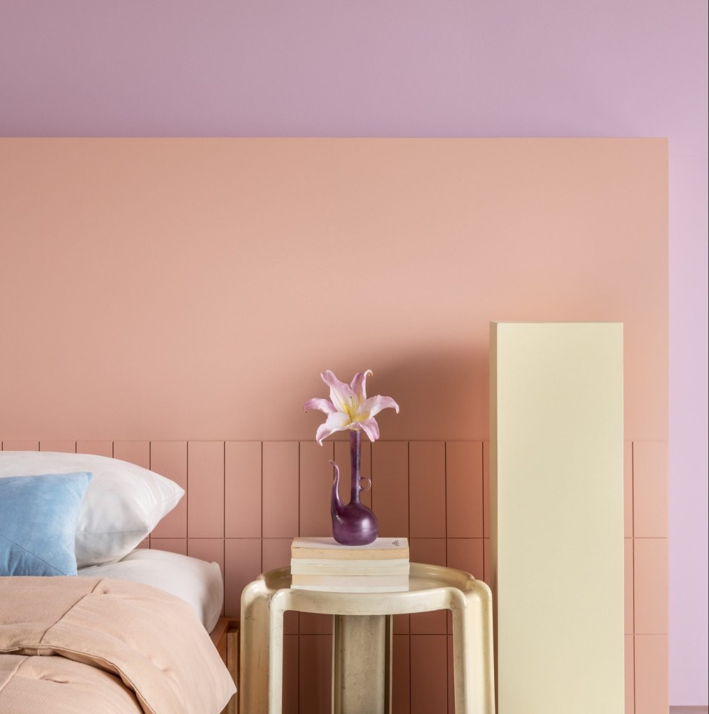 Quarto com parede pintada em tons de rosa e violeta