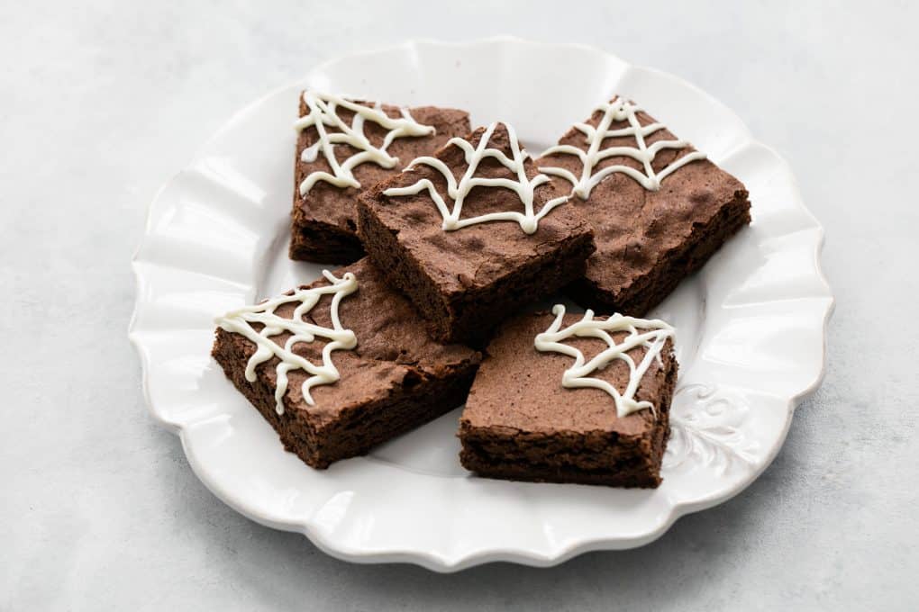 brownie de chocolate enfeitado com teias de aranha feitas de chocolate branco