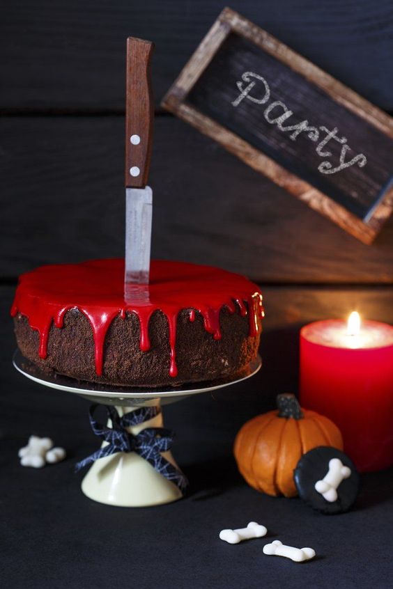 Bolo de chocolate com calda vermelha e uma faca em cima