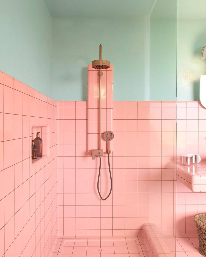 Banheiro com meia parede revestida de azulejos rosas