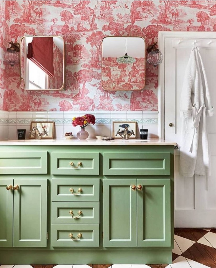 Banheiro com armário verde e papel de parede estampado