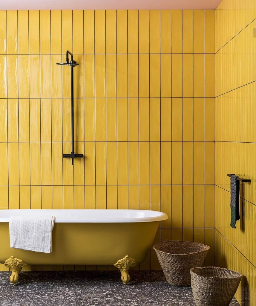 Banheiro com banheira solta e subway tiles amarelos