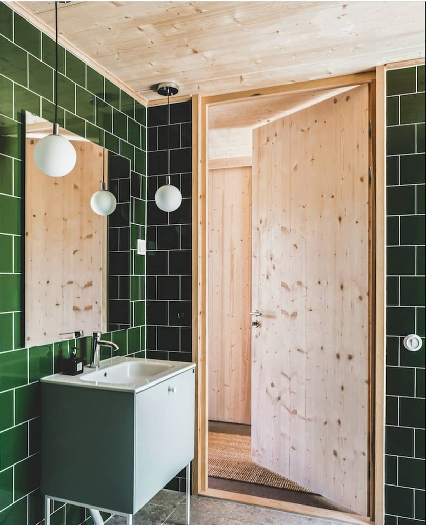 Banheiro com subway tiles verdes e revestimentos em madeira