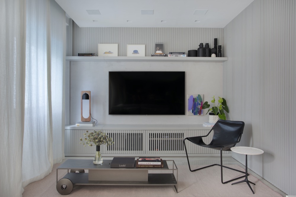 sala de estar com cores neutras e painel de TV