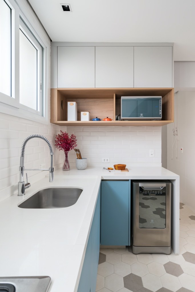 cozinha com armários azuis e piso estampado