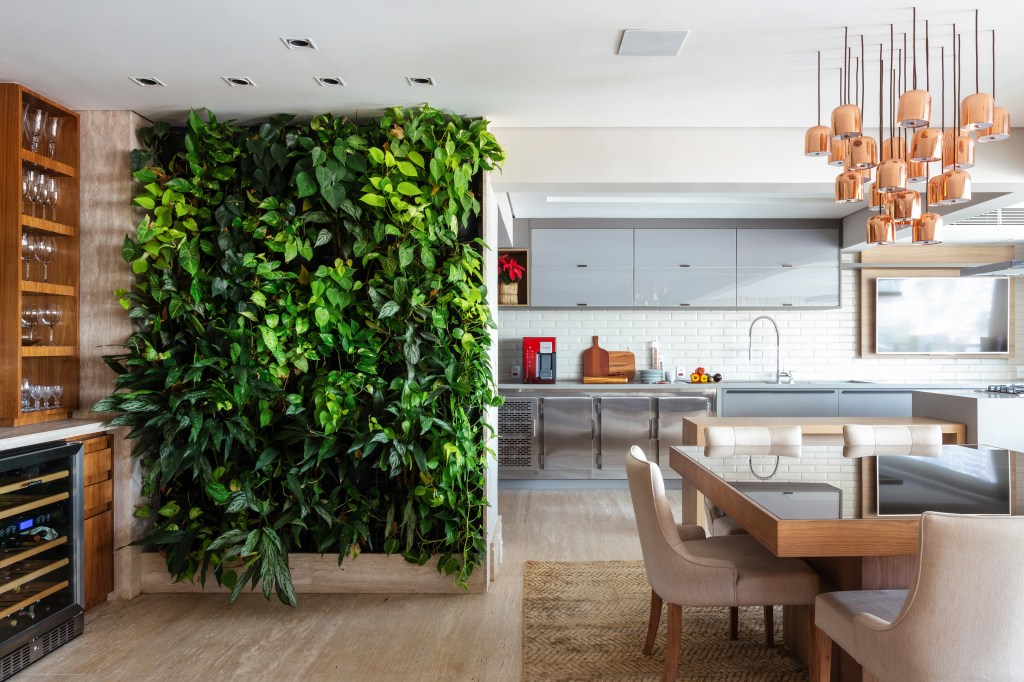 Sala integrada com cozinha com rodapé que acompanha o piso; jardim vertical