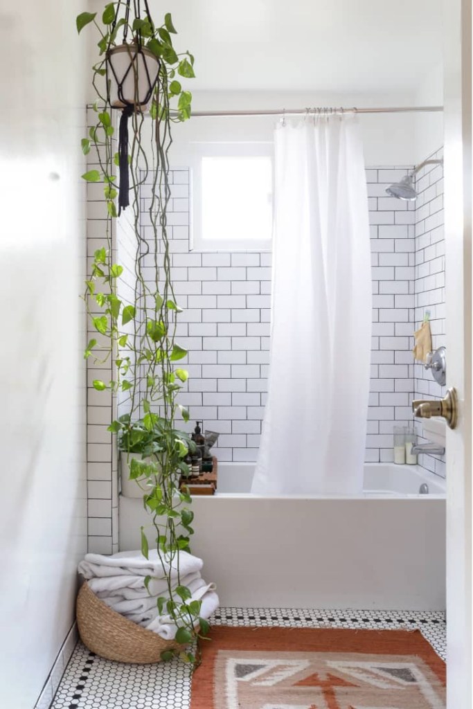 13-dicas-para-decorar-banheiros-pequenos-casa.com–9 Banheiro branco com ladrilhos retangulares branco com uma banheira branca e uma planta pendente do lado esquerdo da área de banho