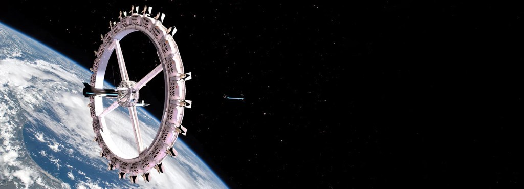 em-2027-teremos-um-hotel-no-espaco-casa.com-1 Estação espacial em órbita com a maio parte da imagem sendo o espaço, escuro, e o fundo atrás da estação sendo a Terra
