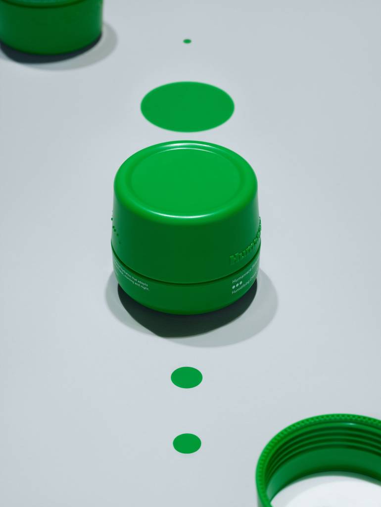 pharrell-williams-lanca-linha-de-produtos-de-skincare-pela-humanrace-casa.com-4 Produto de cuidado facial, com embalagem verde, cilíndrica em fundo branco azulado