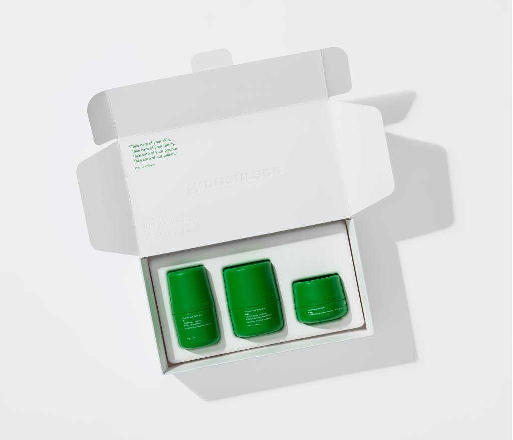 pharrell-williams-lanca-linha-de-produtos-de-skincare-pela-humanrace-casa.com-6 Caixa branco aberta com os três produtos de cuidado facial, de embalagens verdes.