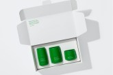 Caixa branco aberta com os três produtos de cuidado facial, de embalagens verdes.