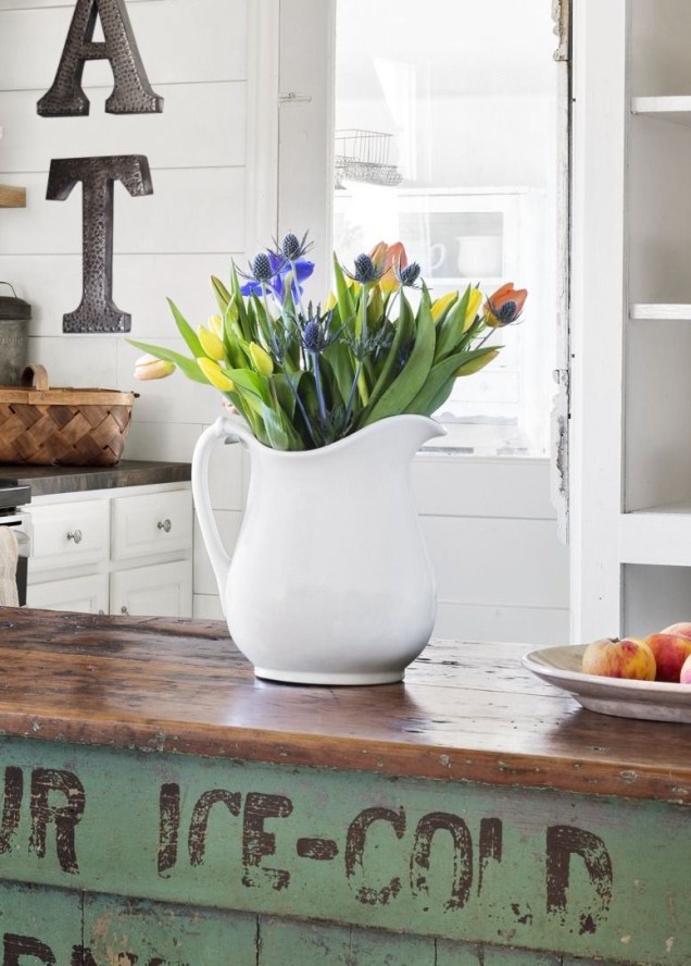 Use a sua peça de porcelanato favorita para exibir folhas recém-colhidas na cozinha. Colocar uma moeda no fundo da jarra ajudará as tulipas a ficarem mais tempo viradas para cima