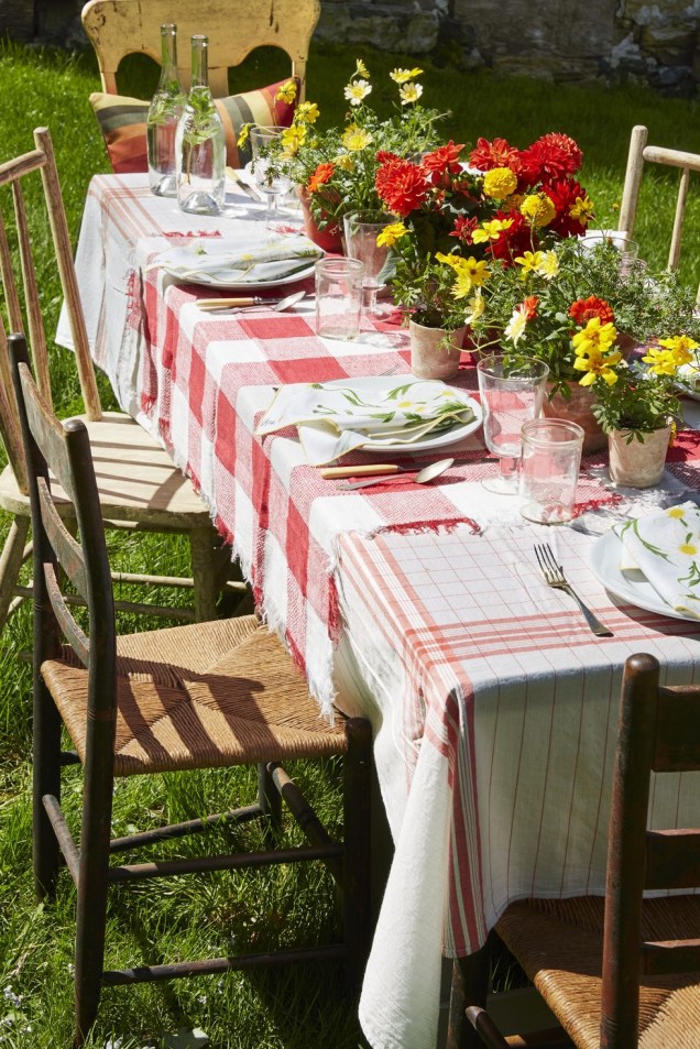 Ao realizar o seu próximo churrasco no quintal, coloque toalhas de mesa vintage e um "corredor" de potes de terracota cheios de flores para os convidados levarem para casa ao fim da noite