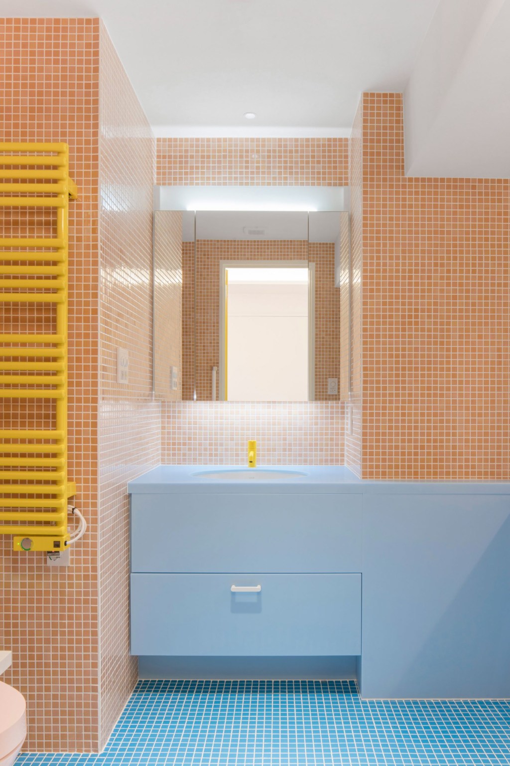 Banheiro com ladrilhos coloridos laranjas e azuis