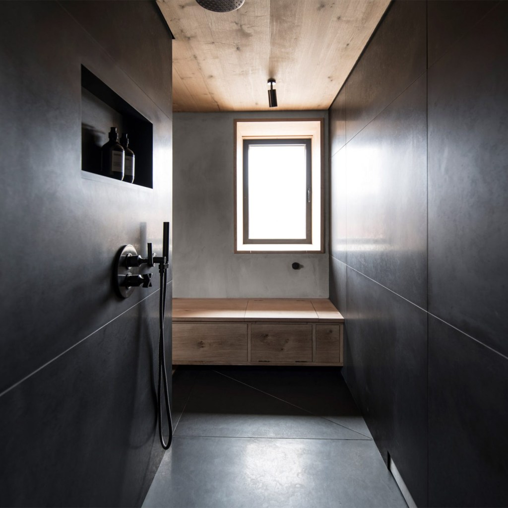 Banheiro minimalista com revestimento preto