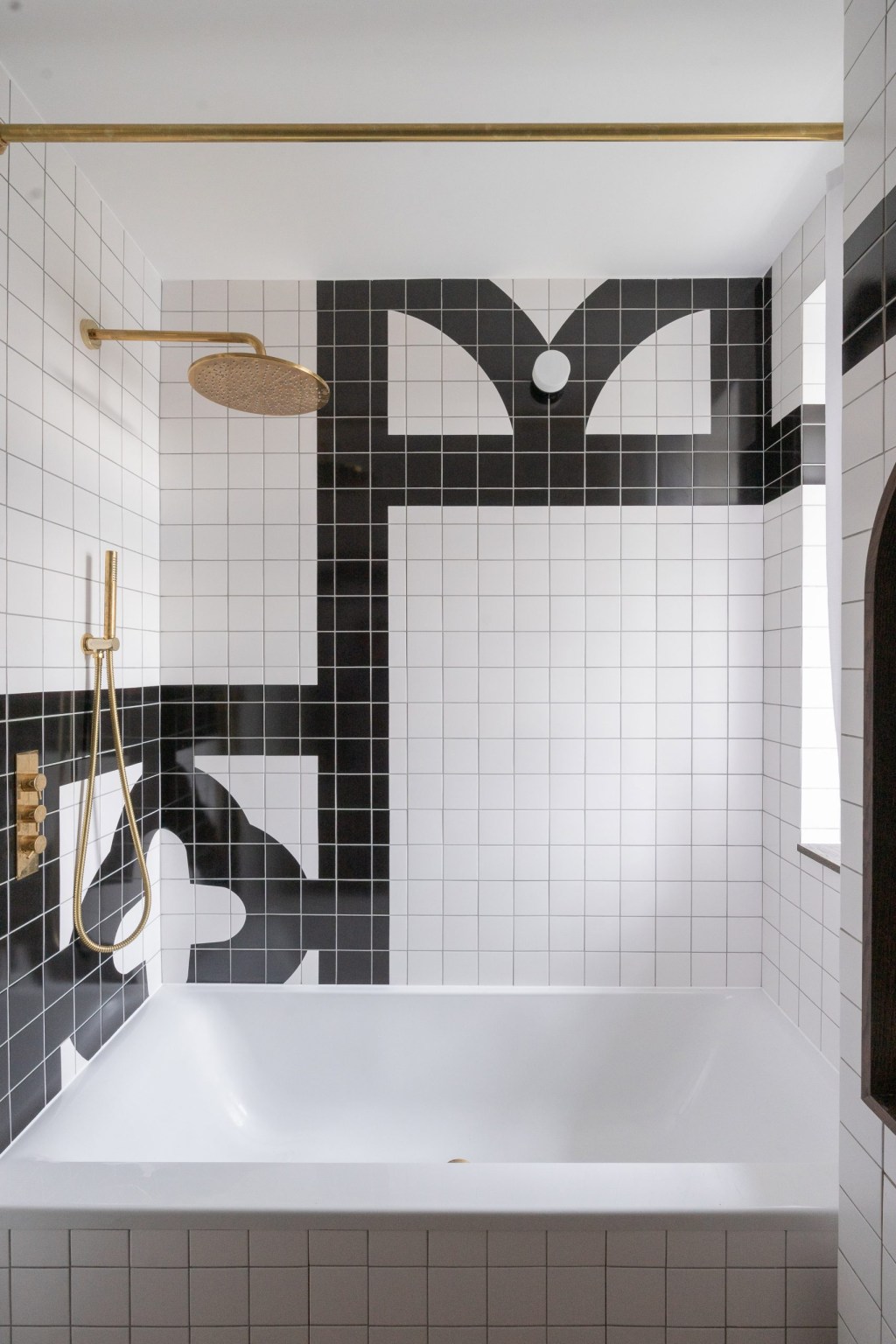 Banheiro com banheira e ladrilhos brancos e pretos