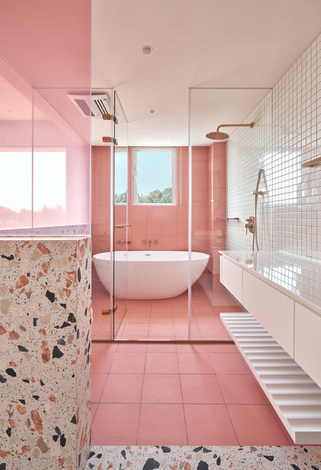 Banheiro com paredes rosa e detalhes em terrazzo