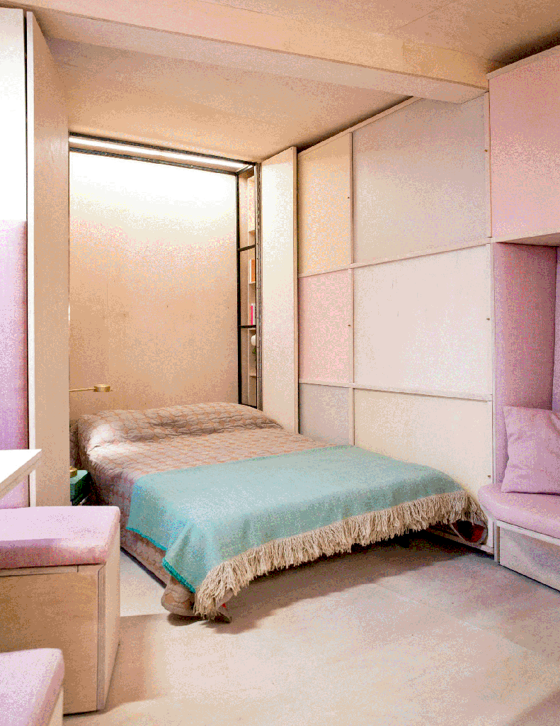 Gif com quarto com paredes em madeira e piso em madeira. Estante em tons de rosa e laranja claro. Espaço para sofá rosa em forma de nicho. Portas abrem e revelam cama retrátil.
