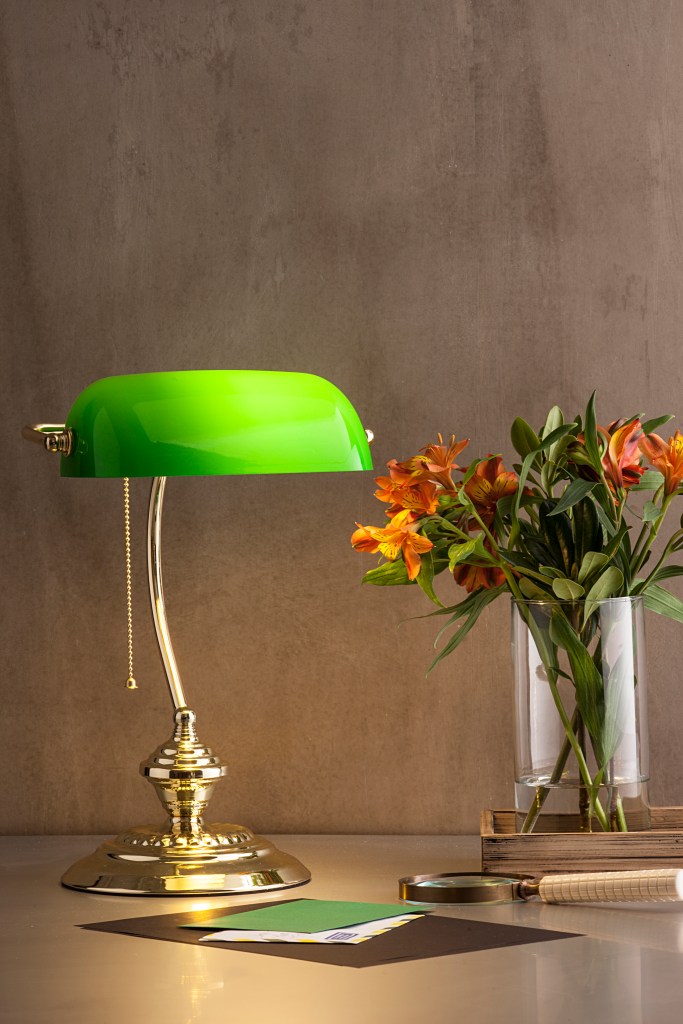 Luminária estilo clássico na cor verde neon, sobre mesa com vaso de flores