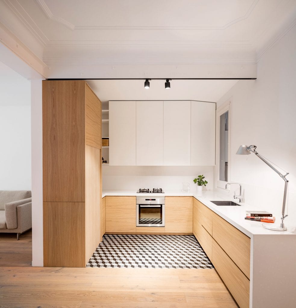 Cozinha em formato de u minimalista com marcenaria em tom madeira e branca