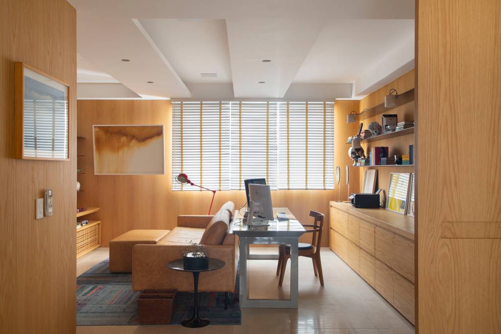 8-design-assinado-e-muita-arte-marcam-decor-desta-cobertura-duplex-de-400-m-2 Sala de TV com home office integrado com paredes revestidas de peroba
