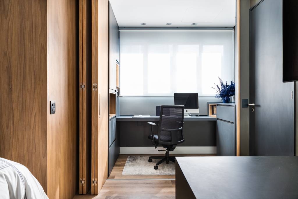 casa-de-280-m²-e-reformada-para-aproveitar-melhor-os-espacos-casa-vila-mariana-julia-otaga-casa.com-fernando-crescenti-36 Escritório no quarto do casal, com porta camarão para fechar o espaço após o uso. A madeira clara da porta combina com os móveis e parede escura