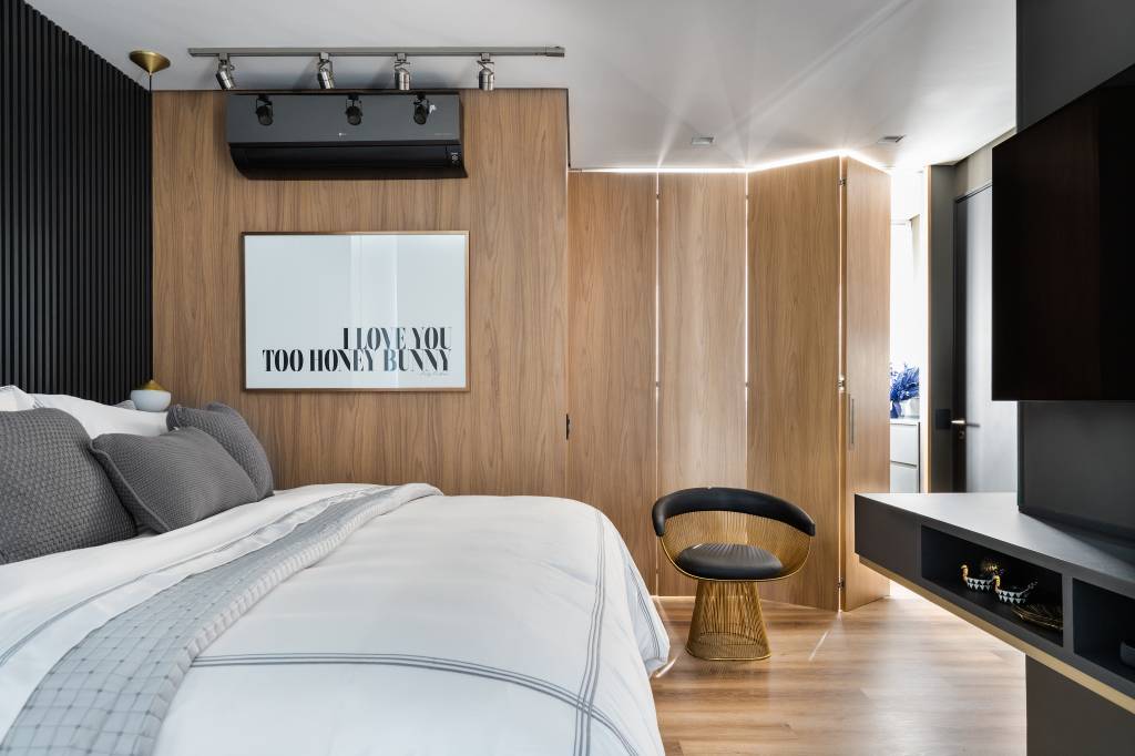 Quarto do casal, com parede revestida em madeira, com quadro branco escrito 