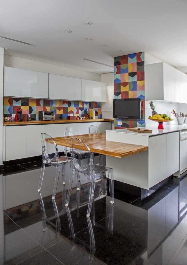 casa-segura-para-criancas-casa.com-karina-korn-eduardo-pozella-1 Cozinha com piso escuro, bancada de madeira com cadeira de acrilico e backsplash de ladrilhos coloridos