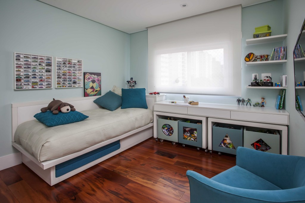 casa-segura-para-criancas-casa.com-karina-korn-eduardo-pozella-2 quarto com piso de madeira, cama com roupa cinza e almofada azuis