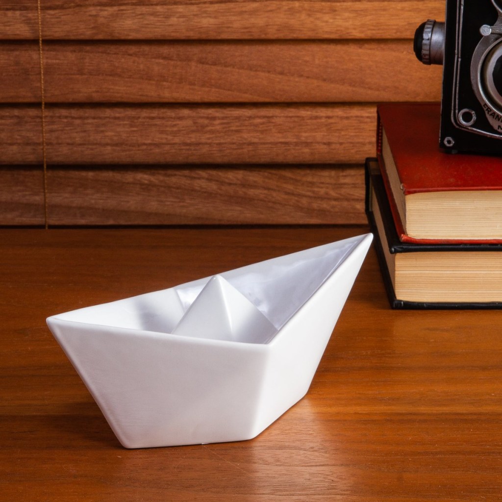 como-decorar-com-a-ceramica-casa.com-etna-5 Barco de papel de cerâmica, sobre bancada de madeira com livros e máquina fotográfica antiga ao fundo
