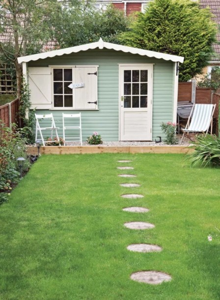 37-cantinhos-de-jardinagem-para-relaxar-e-cuidar-das-plantas-gardeningetc-05 Não deixe a fachada da cabana de fora! Esse telhado possui bordas recortadas, venezianas tradicionais e tons suaves de azul esverdeado. Um caminho de pedras que leva até o cômodo da casa o destaca ainda mais.