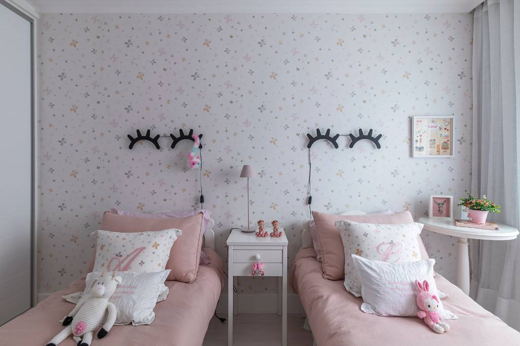 como-escolher-a-luminaria-casa.com-7_Carina_Dal_Fabbro_Foto_Rafael_Renzo Quarto infantil, com duas camas com roupa rosa e luminárias sobre elas em formato de olhos fechados com cílios