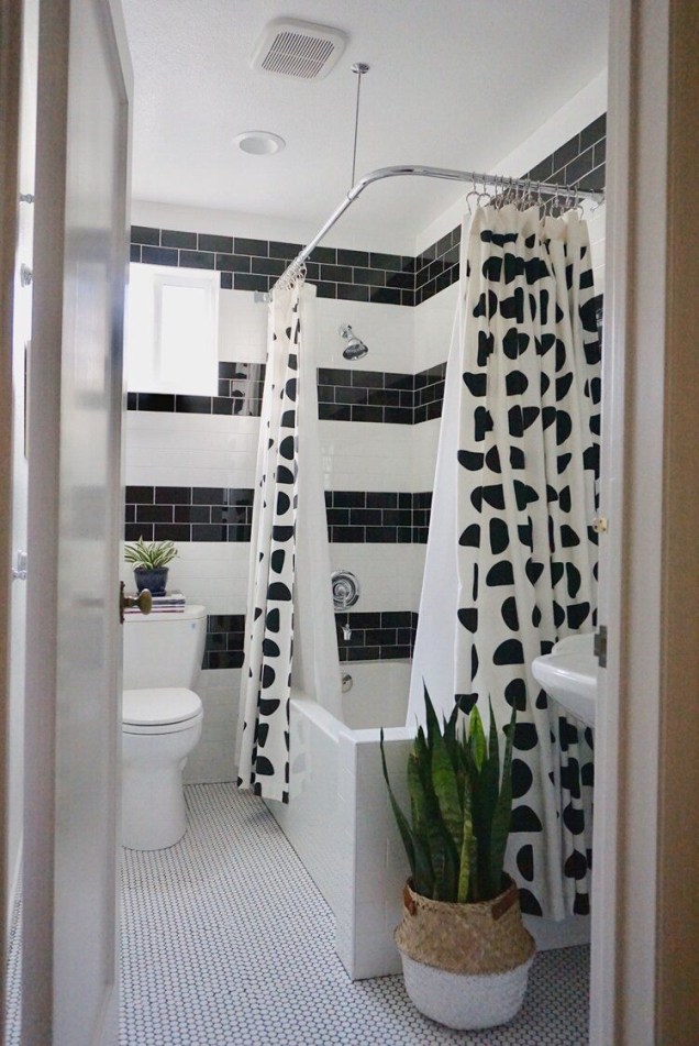 Procura um efeito dramático para algum cômodo da sua casa? O padrão em listras preto e branco ficou divertido nesse banheiro! A cortina de chuveiro cheia de desenhos amplia o estilo geométrico vigoroso.