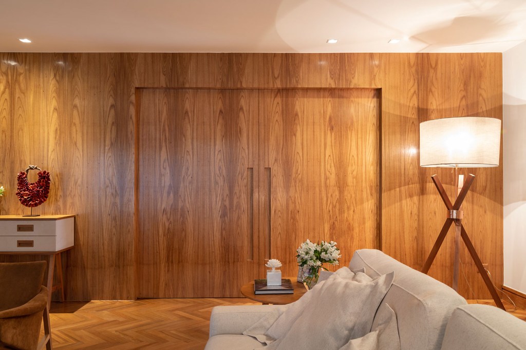 Sala de estar com uma ampla porta e paredes revestidas de madeira.