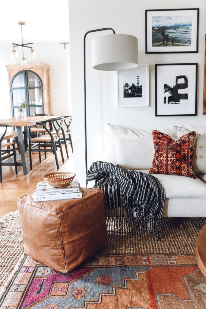 Sala com sofá branco e pufe em couro