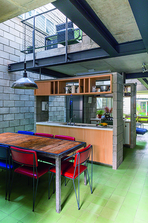 O casal leva a sério a ideia de uma cozinha aberta – o ambiente é configurado apenas por dois pórticos, também montados com blocos de concreto. O primeiro deles, perto da mesa de jantar, abriga a bancadacom pia.