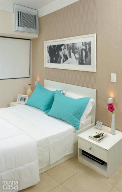 O quarto da designer de interiores Gabriela Alencar tem apenas o essencial: um par de criados-mudos e a cama com gavetões para lençóis, mantas e toalhas. A parede da cabeceira foi revestida de papel de parede em dois padrões com texturas beges.