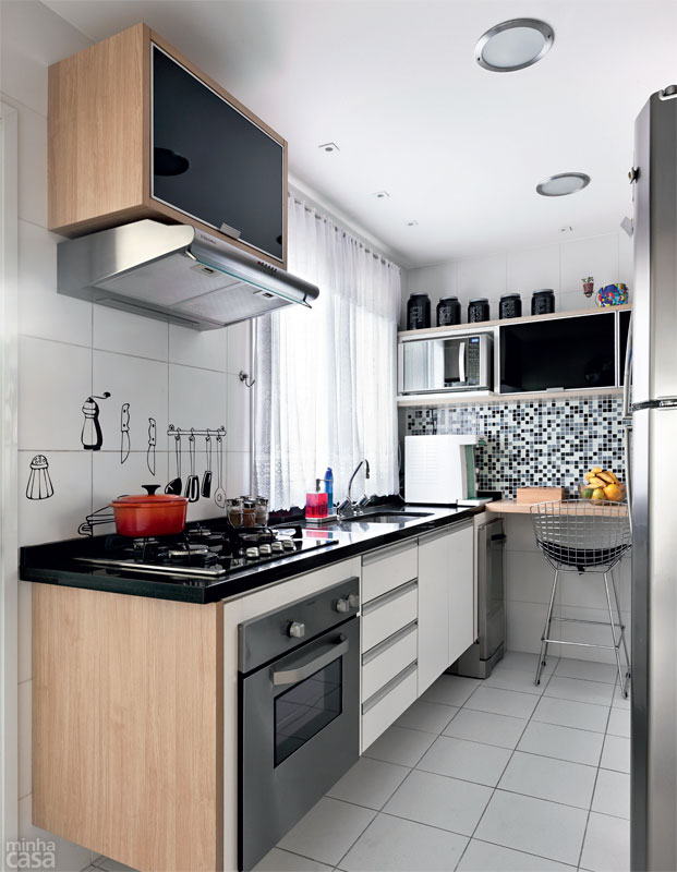 A cozinha com cerca de 10 m² funciona bem sem mesa, a qual exigiria boa parte da metragem destinada à circulação. Bastou uma bancada no canto para fazer a família feliz. Pastilhas de vidro revestem a parede. Projeto de Ana Maria Mouawad Queiroga. A cozinha com cerca de 10 m² funciona bem sem mesa, a qual exigiria boa parte da metragem destinada à circulação. Bastou uma bancada no canto para fazer a família feliz. Pastilhas de vidro revestem a parede. Projeto de Ana Maria Mouawad Queiroga.