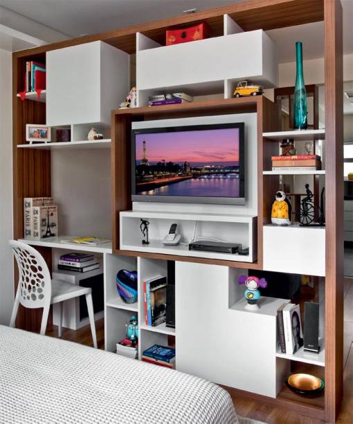 Insatisfeito por ter sala e quarto dividindo um único ambiente, o casal encomendou uma divisória à arquiteta Adriana Fontana, de São Paulo, que resolveu o problema com esta estante dupla face. Junto à parede, uma das prateleiras, a 69 cm do chão, funciona como escrivaninha e pode ser usada de ambos os lados. Insatisfeito por ter sala e quarto dividindo um único ambiente, o casal encomendou uma divisória à arquiteta Adriana Fontana, de São Paulo, que resolveu o problema com esta estante dupla face. Junto à parede, uma das prateleiras, a 69 cm do chão, funciona como escrivaninha e pode ser usada de ambos os lados.