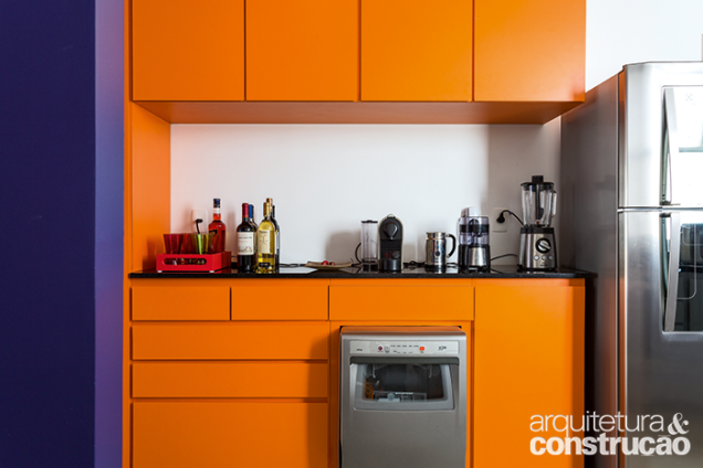 No projeto assinado por Rodrigo Ohtake, a marcenaria de design clean ganha vida no laminado laranja com acabamento fosco
