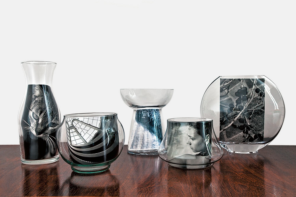 Fotografias expostas em vasos de vidro.