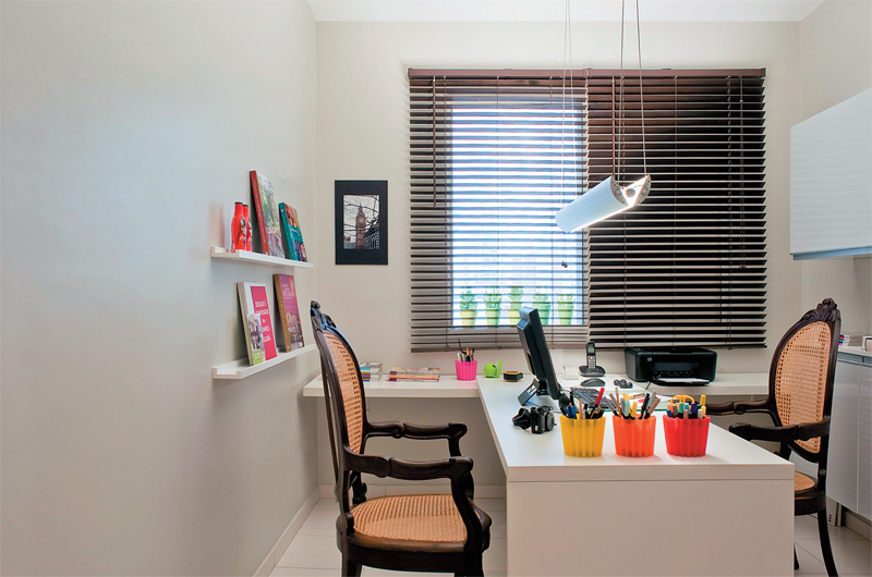 O principal elemento deste ambiente é a bancada em T, integrada por mesa de trabalho e área de apoio. Prateleiras estreitas acomodam livros de arquitetura. Coloridos cachepôs de silicone, organizam as canetas na bancada. Na janela, adesivos de suculentas dão humor à decoração. Projeto de Neto Porpino. O principal elemento deste ambiente é a bancada em T, integrada por mesa de trabalho e área de apoio. Prateleiras estreitas acomodam livros de arquitetura. Coloridos cachepôs de silicone, organizam as canetas na bancada. Na janela, adesivos de suculentas dão humor à decoração. Projeto de Neto Porpino.