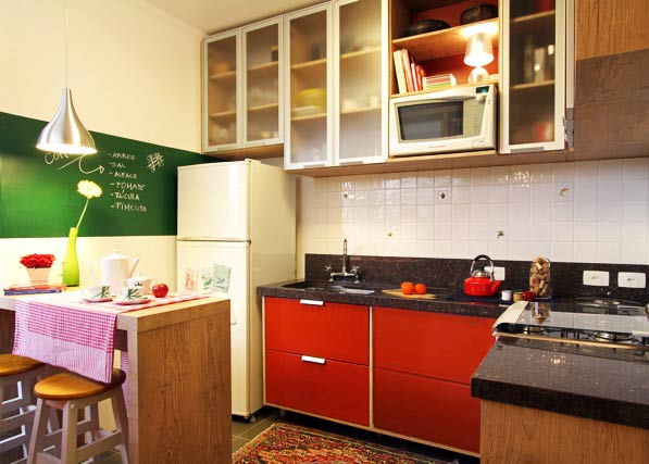 A cozinha projetada pela arquiteta Thais Lenzi Bressiani utiliza o vermelho no armário e em diversos acessórios . Na parede, uma tinta que imita lousa é utilizada para anotar recados e receitas. Para não pesar no ambiente, os armários ganharam portas translúcidas. A cozinha projetada pela arquiteta Thais Lenzi Bressiani utiliza o vermelho no armário e em diversos acessórios . Na parede, uma tinta que imita lousa é utilizada para anotar recados e receitas. Para não pesar no ambiente, os armários ganharam portas translúcidas.