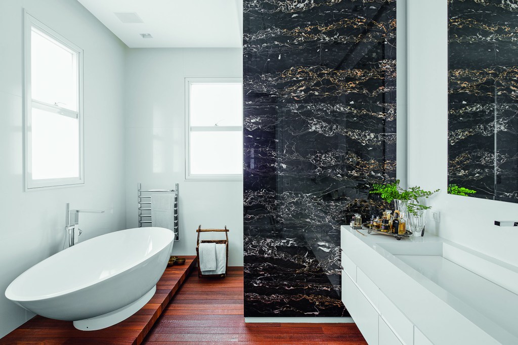 Banheiro; banheira solta; piso de madeira; parede de mármore