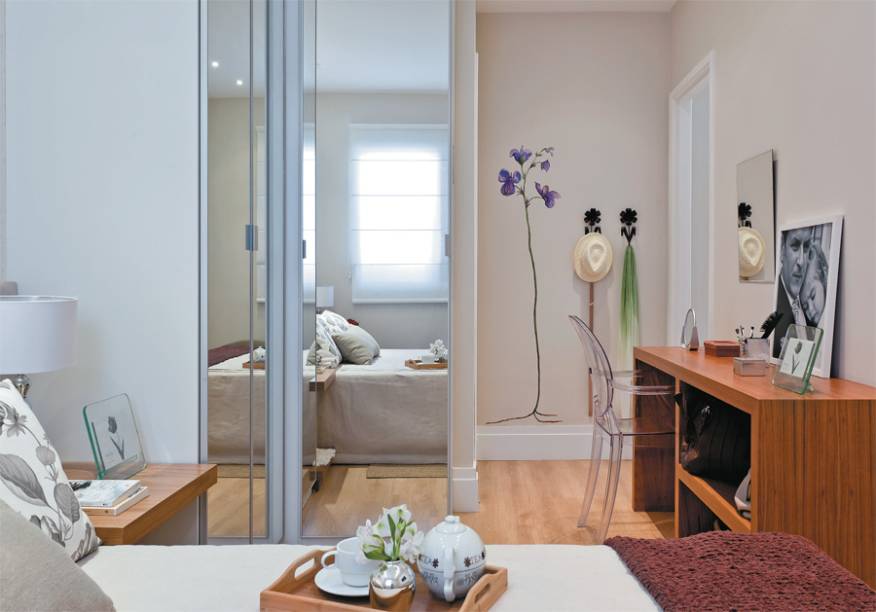 Os florais dão o tom neste quarto. Para a melhor ocupação da área, os armários foram dispostos em L. Folhas de espelho revestem as portas – o recurso faz o ambiente parecer maior. Em frente ao guarda-roupa, a bancada serve de penteadeira ou canto do computador. Projeto de Renata Cáfaro. Os florais dão o tom neste quarto. Para a melhor ocupação da área, os armários foram dispostos em L. Folhas de espelho revestem as portas – o recurso faz o ambiente parecer maior. Em frente ao guarda-roupa, a bancada serve de penteadeira ou canto do computador. Projeto de Renata Cáfaro.