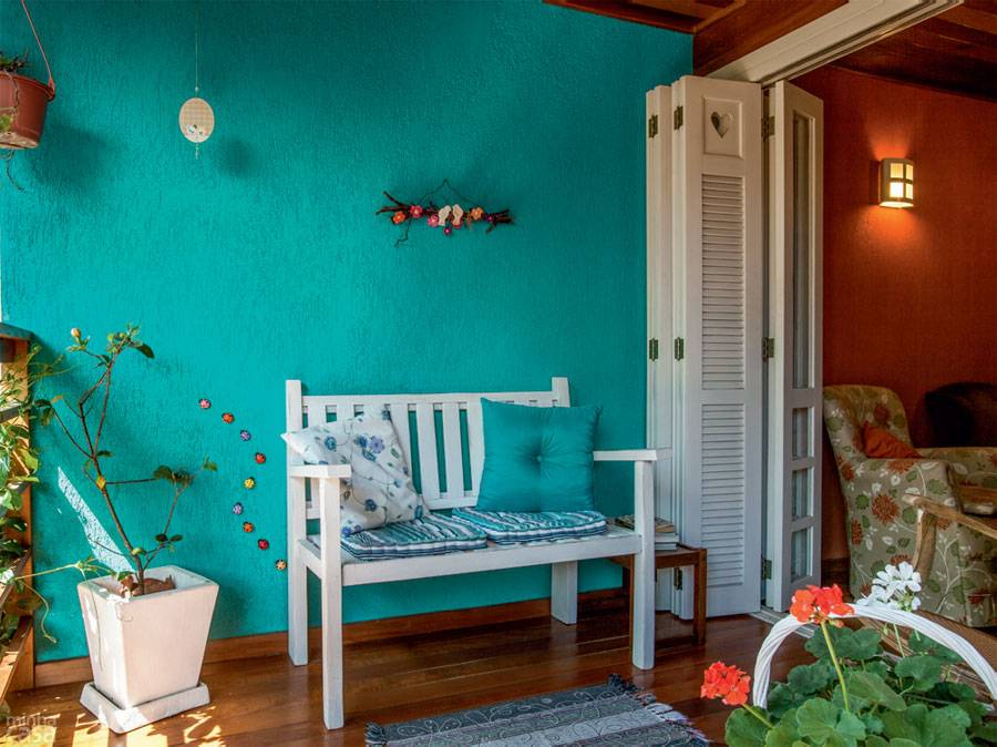 A exemplo do banheiro de baixo, a &uacute;nica alvenaria no n&iacute;vel superior &ndash; ao mesmo tempo parede  da varanda e divisa de terreno &ndash; recebeu textura do tipo grafiato e, sobre ela, pintura no tom Nifty Turquoise (ref. SW-6941, da Sherwin-Williams). O azul &eacute; bem-vindo, pois quebra a sobriedade do interior mais terroso.
