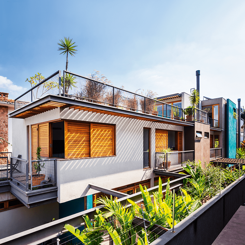 Casa com grandes aberturas é cercada por jardins